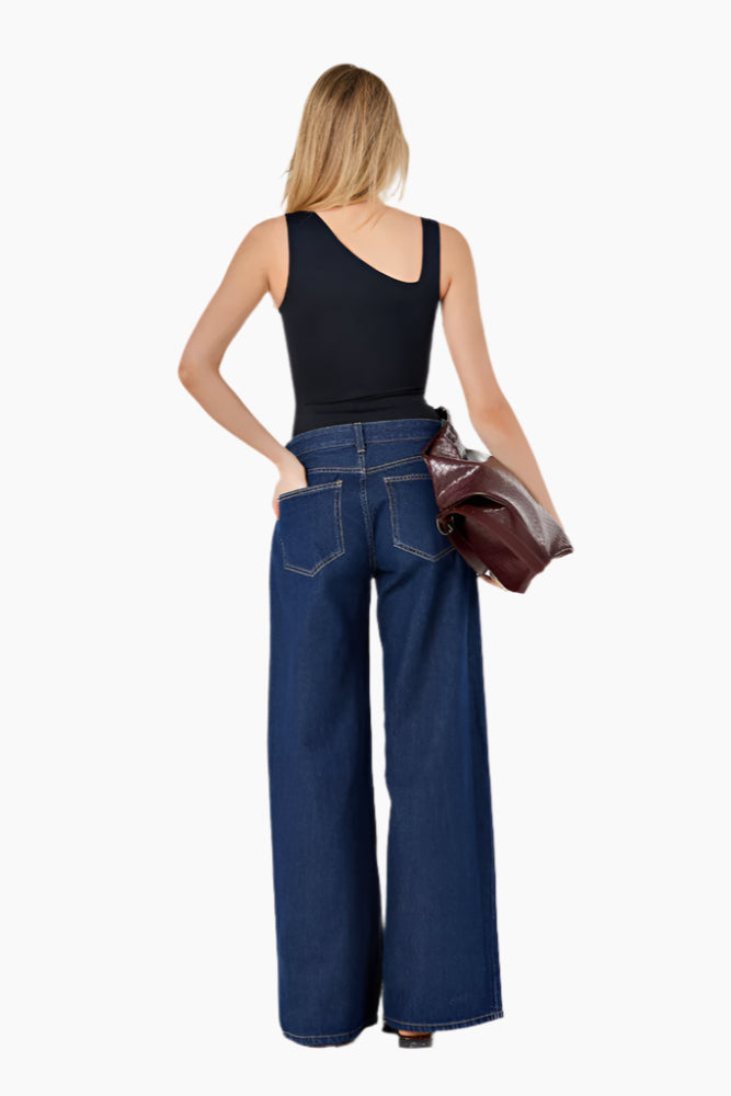 Woman wearing blue jeans and a black top