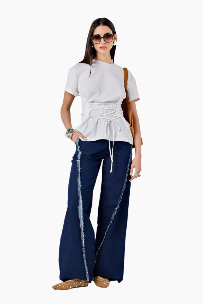 Woman wearing a white top and navy pants