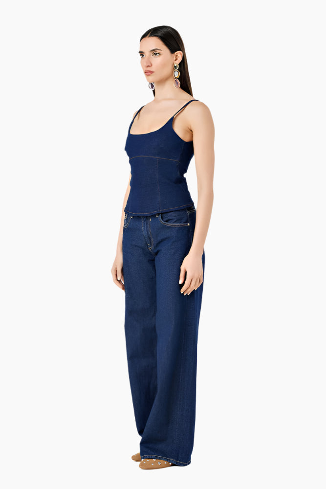 Woman wearing a blue tank top and jeans.