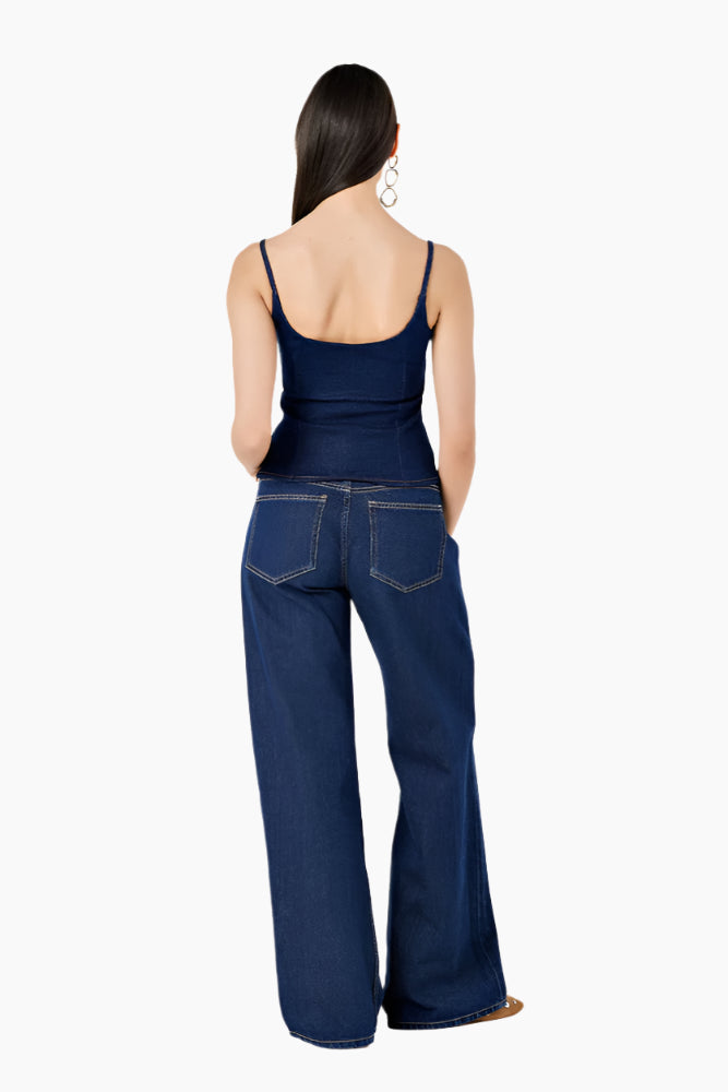 Woman wearing a navy blue sleeveless top and high-waisted jeans