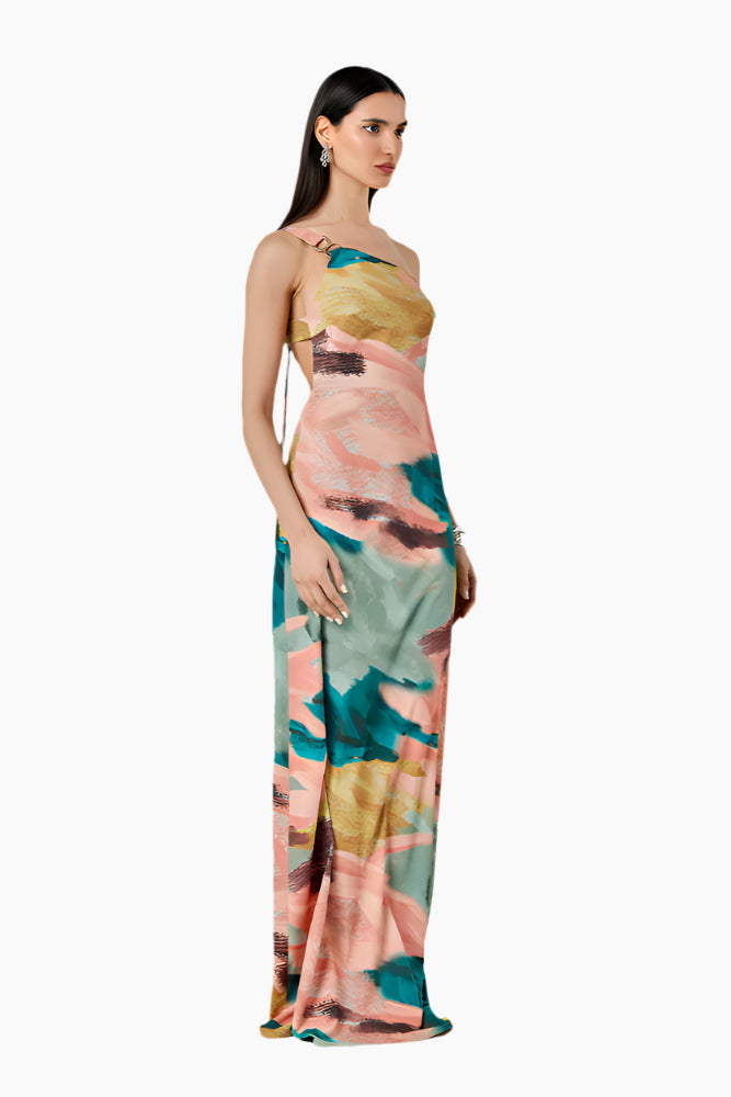 Woman wearing a colorful floral dress. Relaxed-fit asymmetrical one-shoulder dress with a side slit closed by buttons.