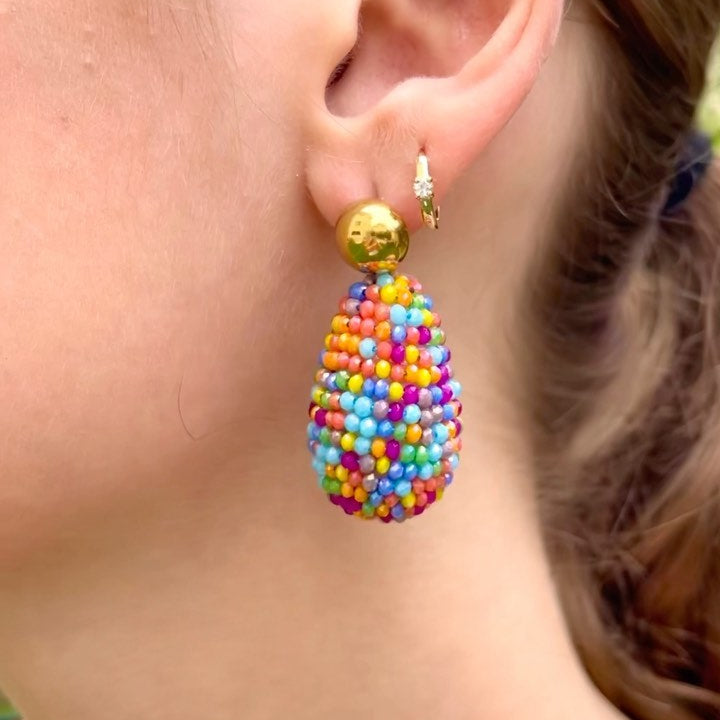 Colorful beaded earring worn by a person