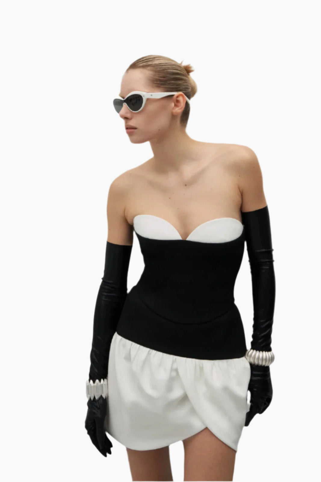 Woman wearing a black and white outfit with long gloves and sunglasses
