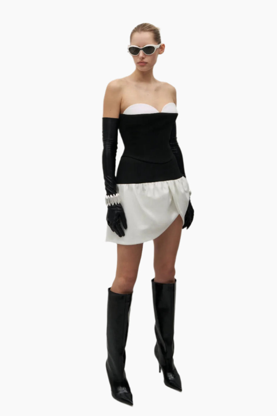 Woman wearing a black and white outfit with high boots