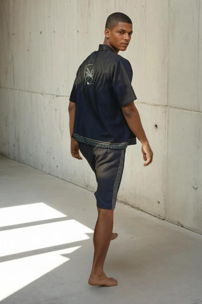 Man wearing a dark blue outfit, t-shirt and matching patterned shorts