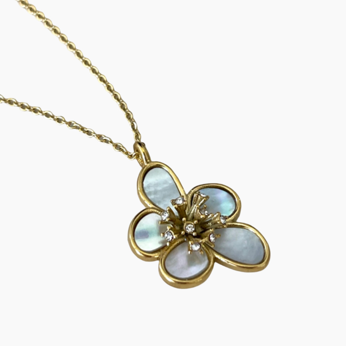 Gold necklace with a flower-shaped pendant featuring mother-of-pearl and diamonds on a white background