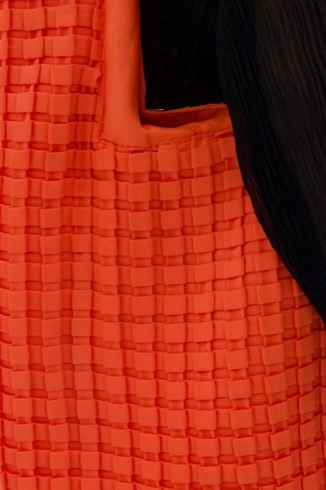 Close-up of a textured orange fabric with a black background
