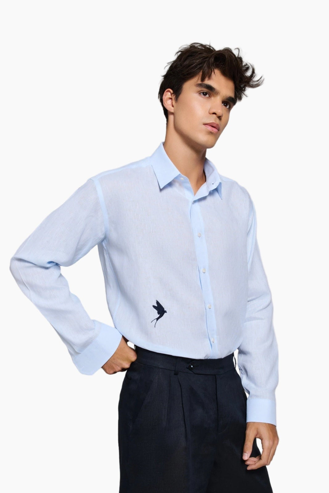 Man wearing a Man wearing a light blue shirt and black shorts : Tailored fit baby blue 100% fine Linen men shirt with a hanging two love birds and a sunset view embroidery on the chest.