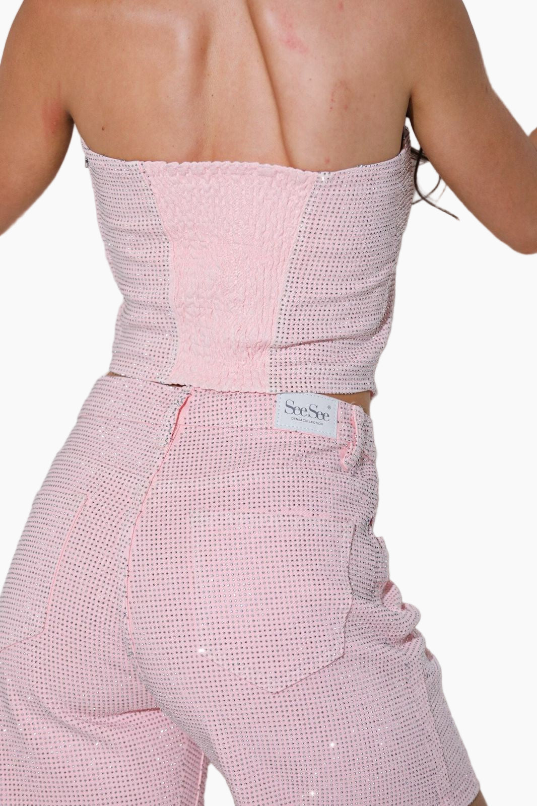 Woman wearing a strapless pink top and matching pants