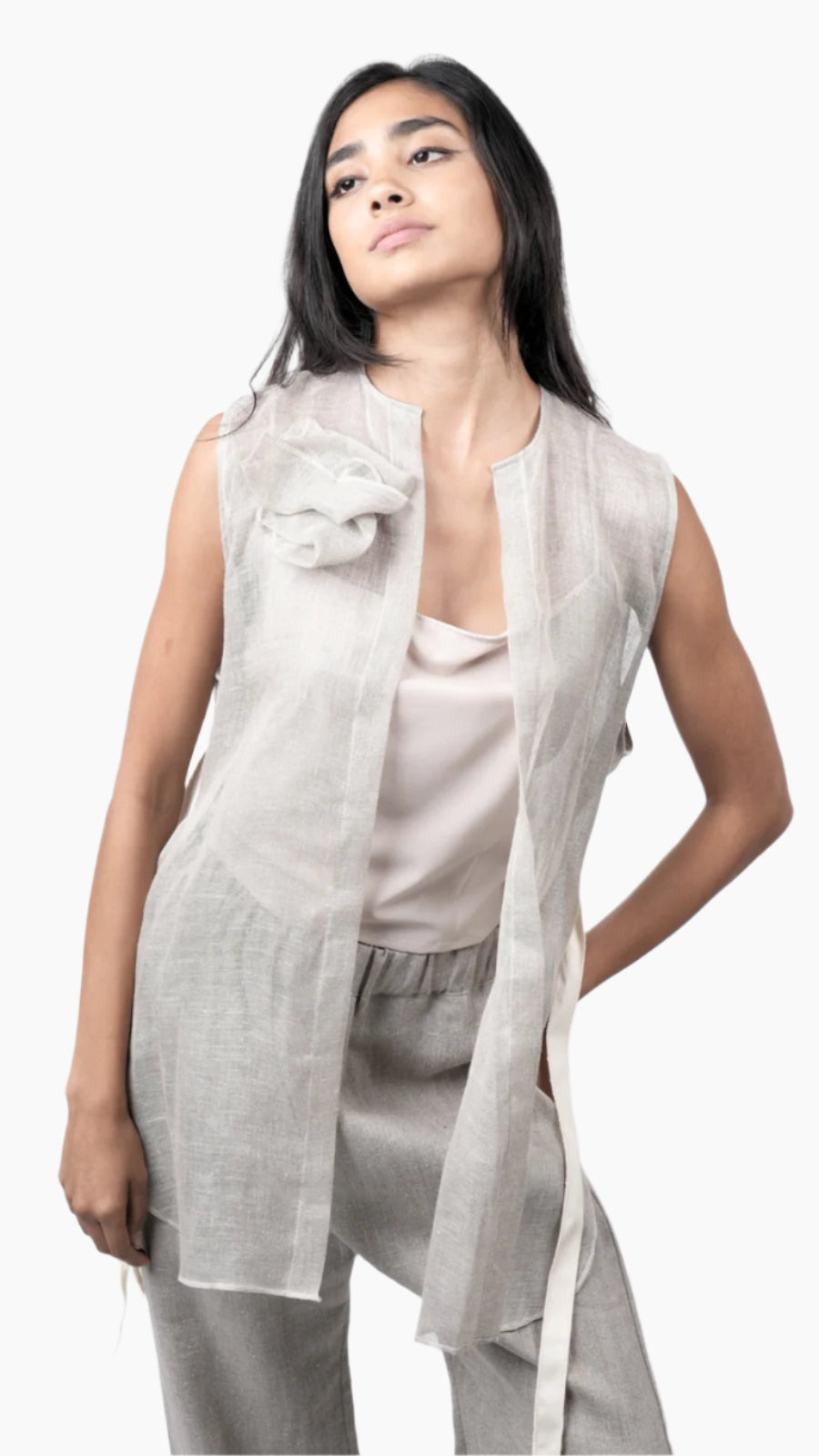 Woman wearing a light gray sleeveless top and pants with a matching duster