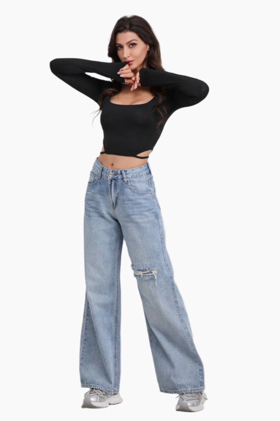 Woman wearing a black crop top and light blue jeans