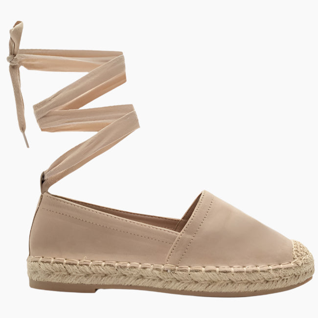 Beige espadrille shoe with strap details on a white background