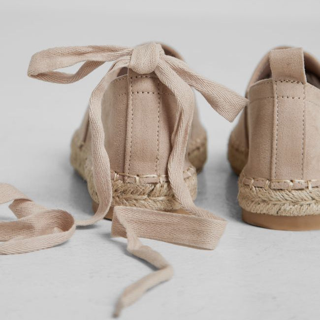 Pair of beige espadrilles with tied laces