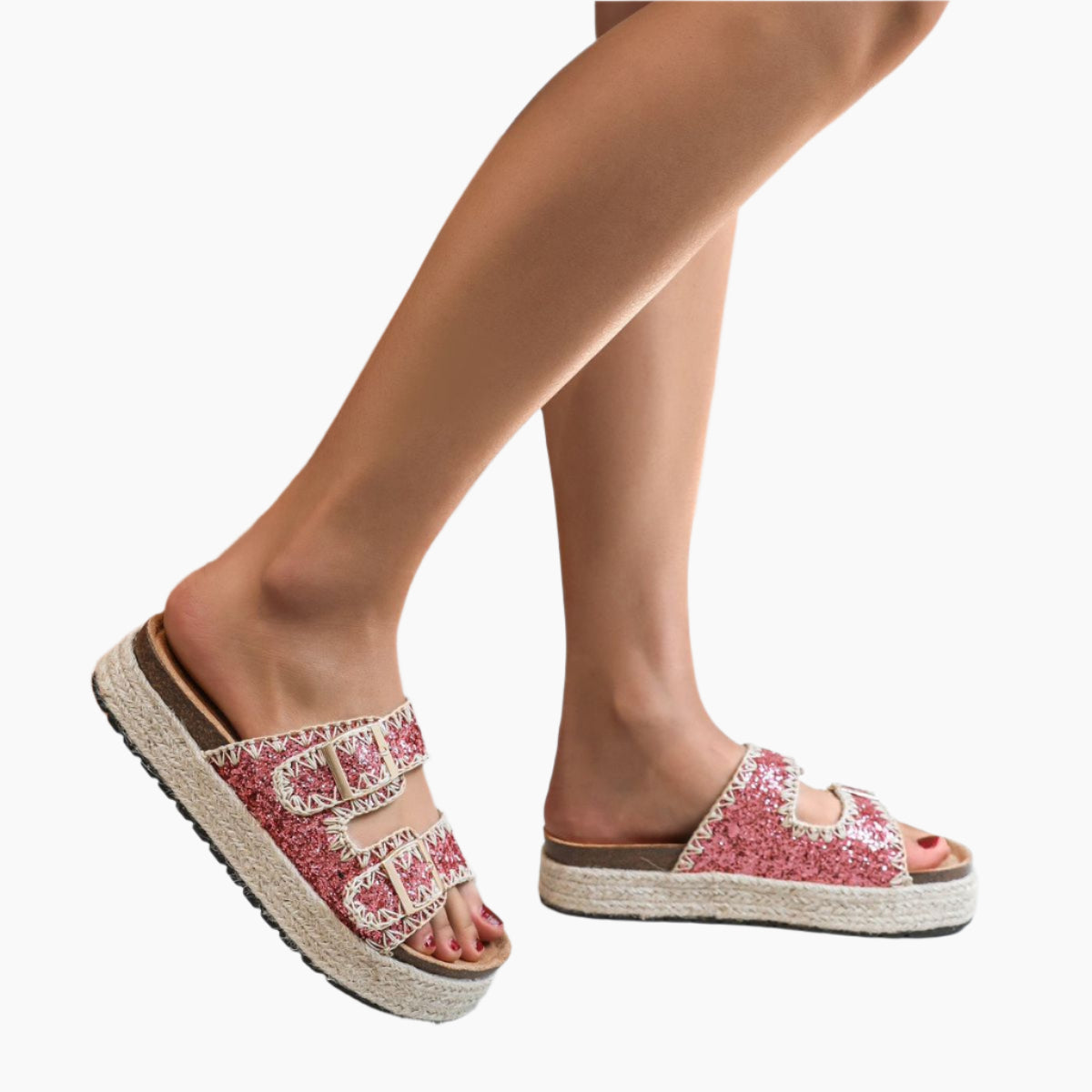 Pink glittery sandals with brown soles worn by a person
