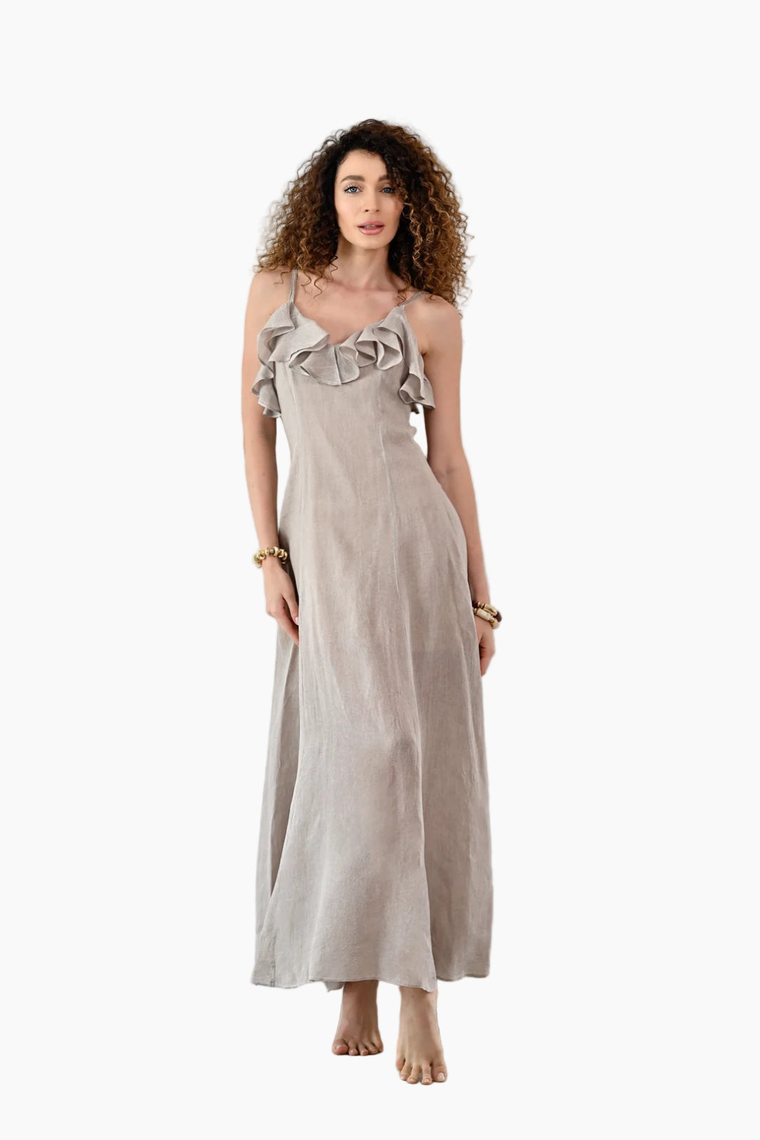 Woman wearing a light gray dress with ruffled straps against a white background