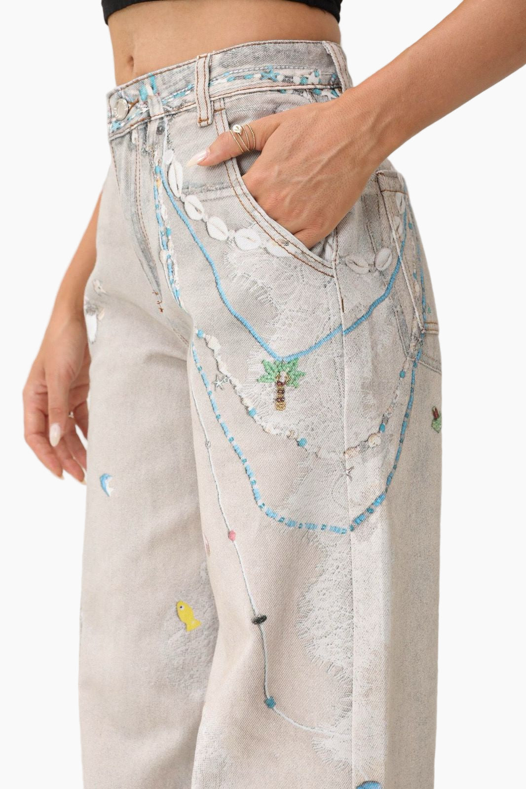 Light-colored jeans with colorful embroidered designs