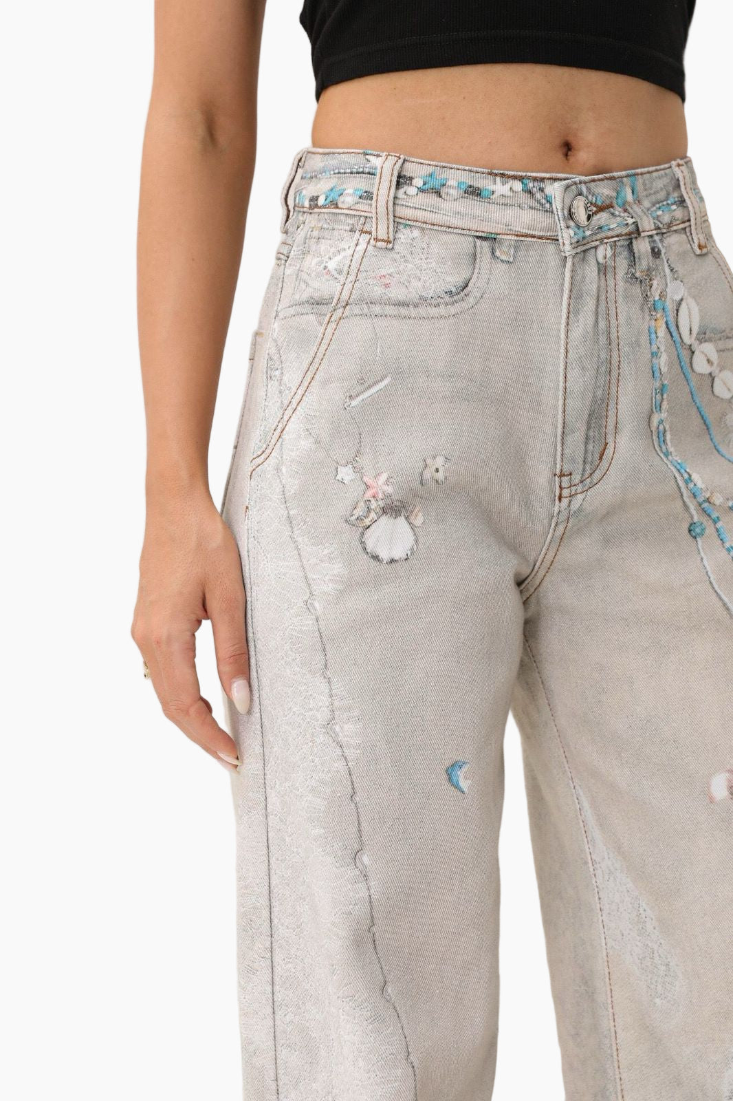 Light gray jeans with decorative elements worn by a person