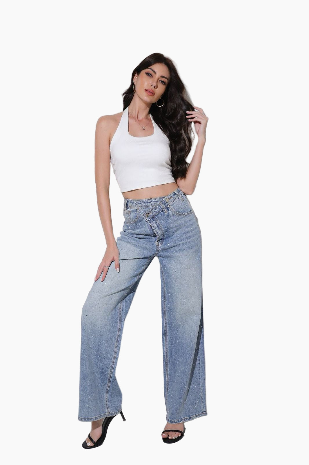 Woman wearing a white crop top and blue jeans