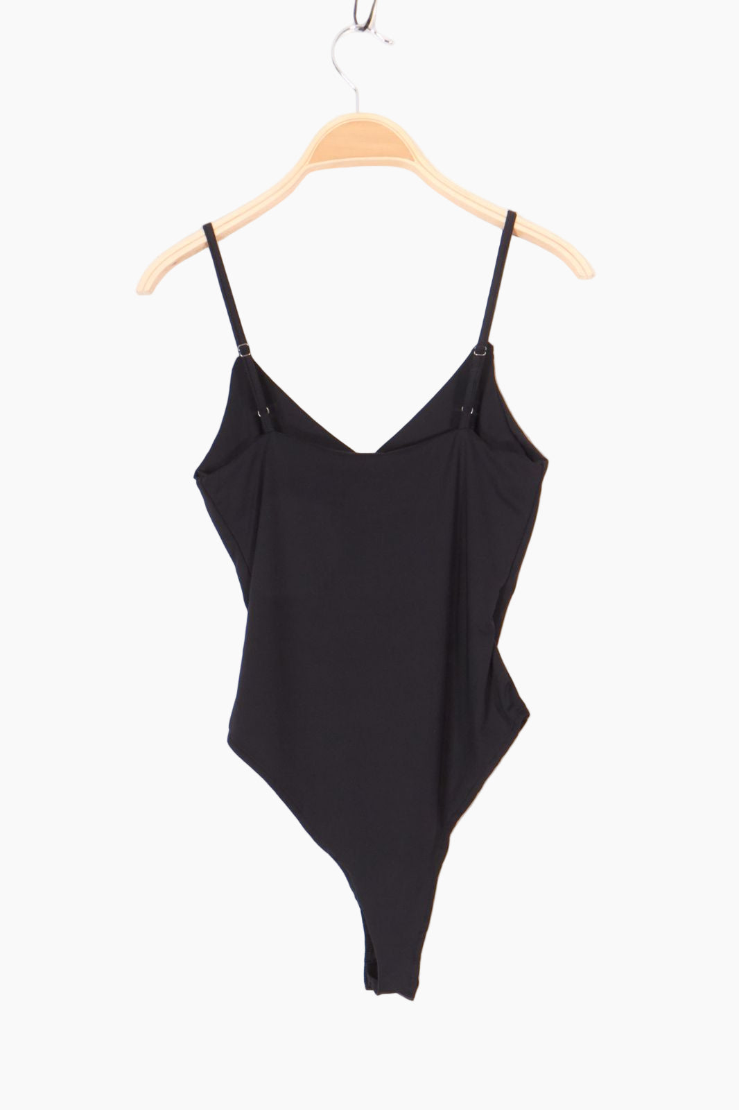 Black swimsuit on a hanger against a white background