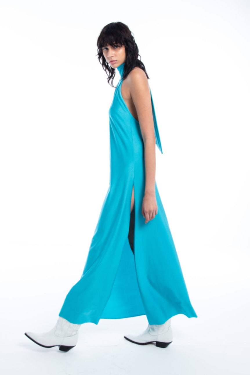 Woman wearing a turquoise dress with a slit