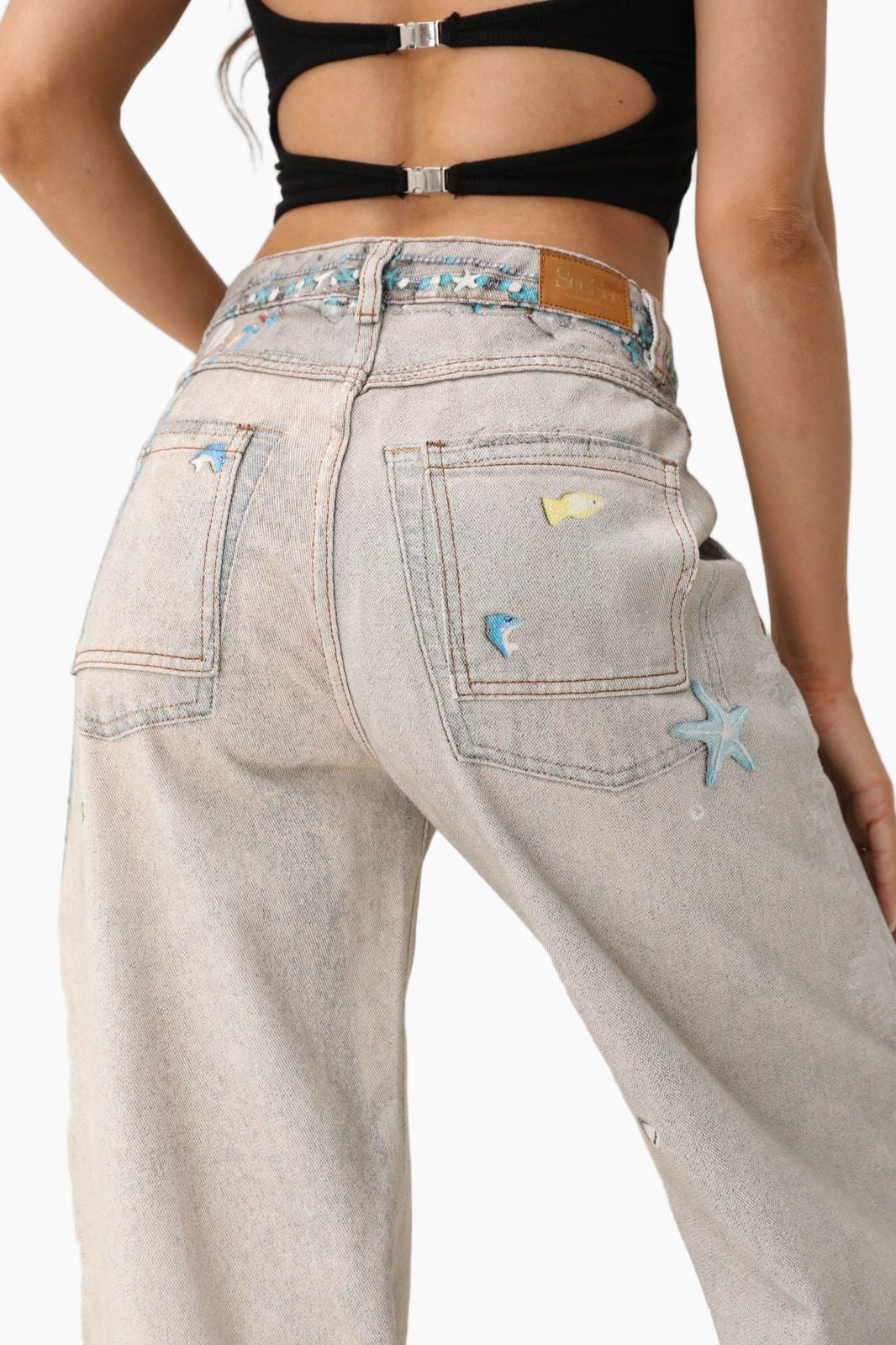 Light-colored jeans with star patches worn by a person