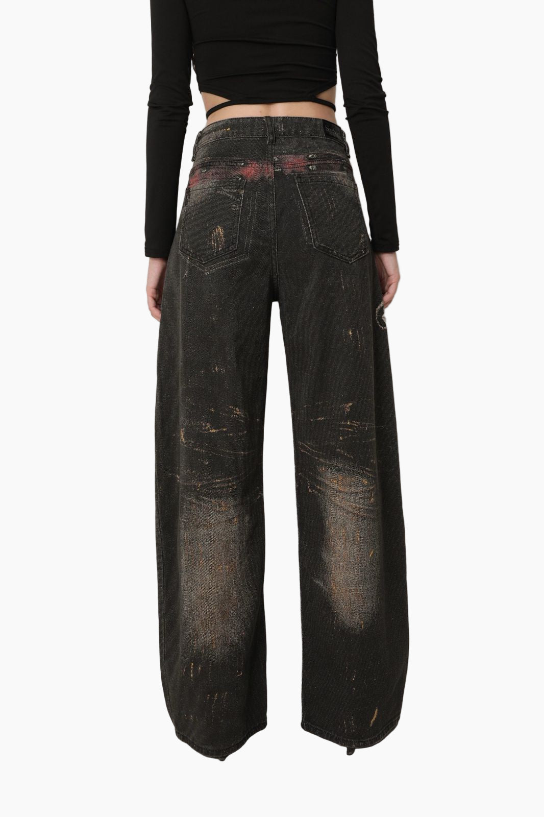 Person wearing dark distressed jeans =
