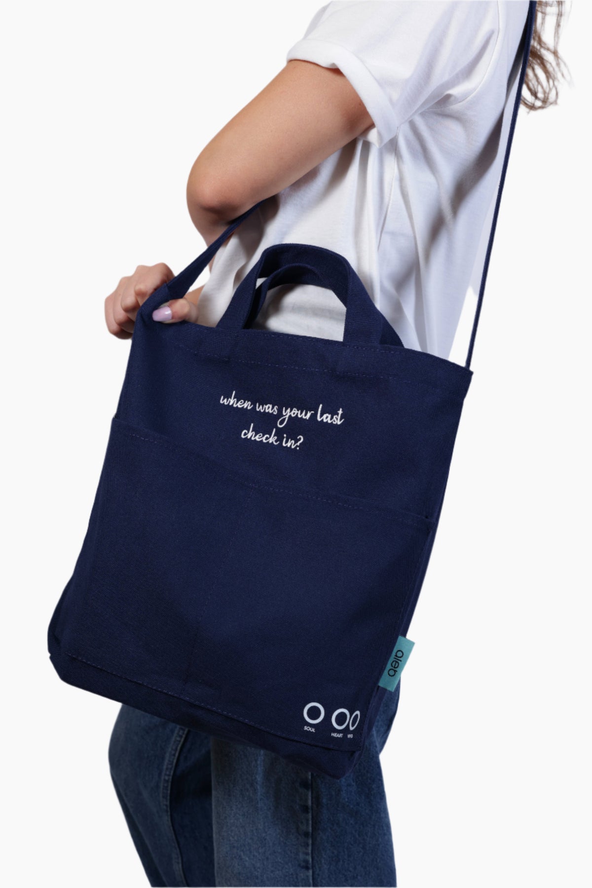 Person wearing a navy blue bag "When was your last check in?" - Unisex Tote Bag