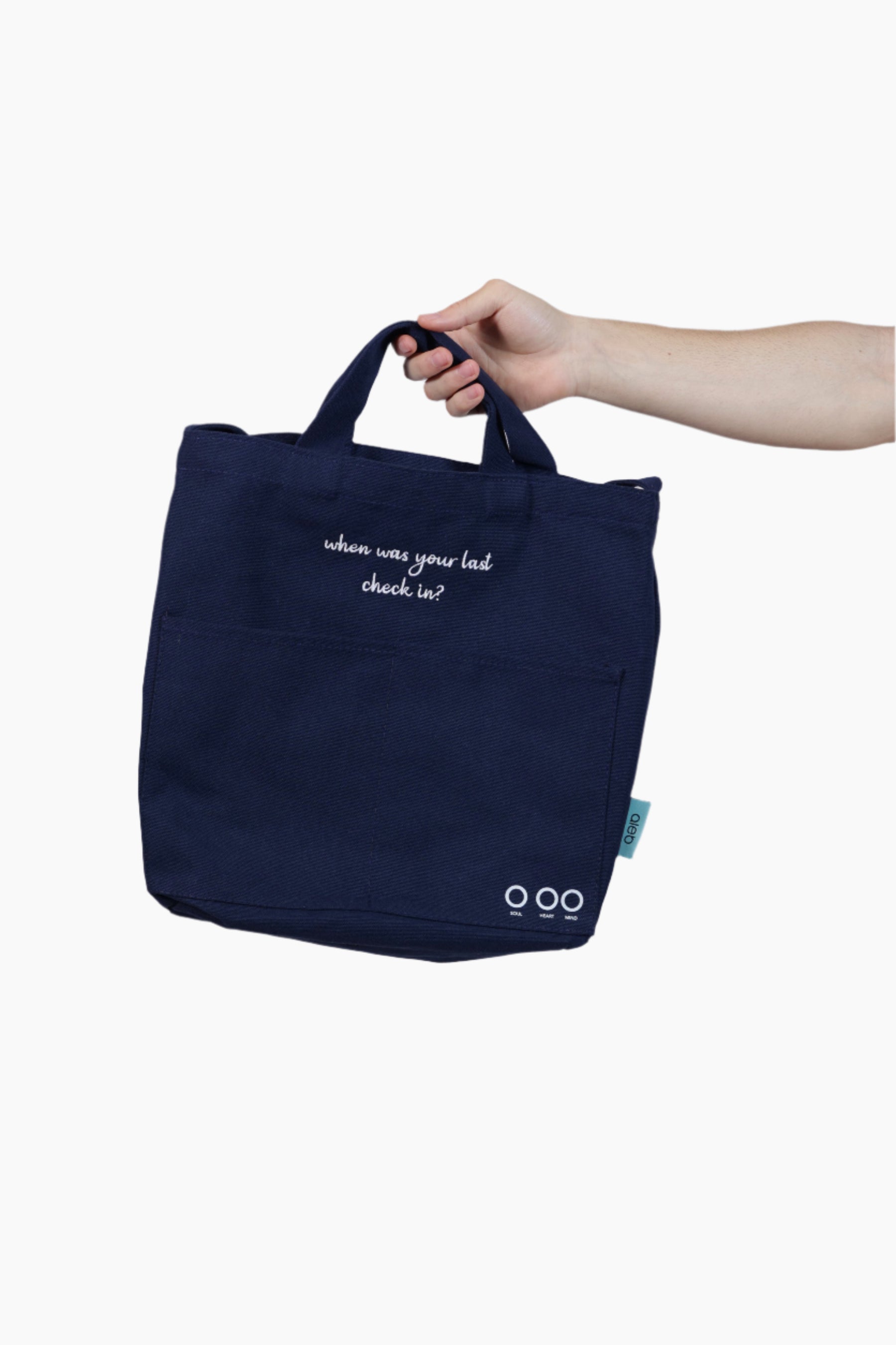 Navy tote bag held by a hand