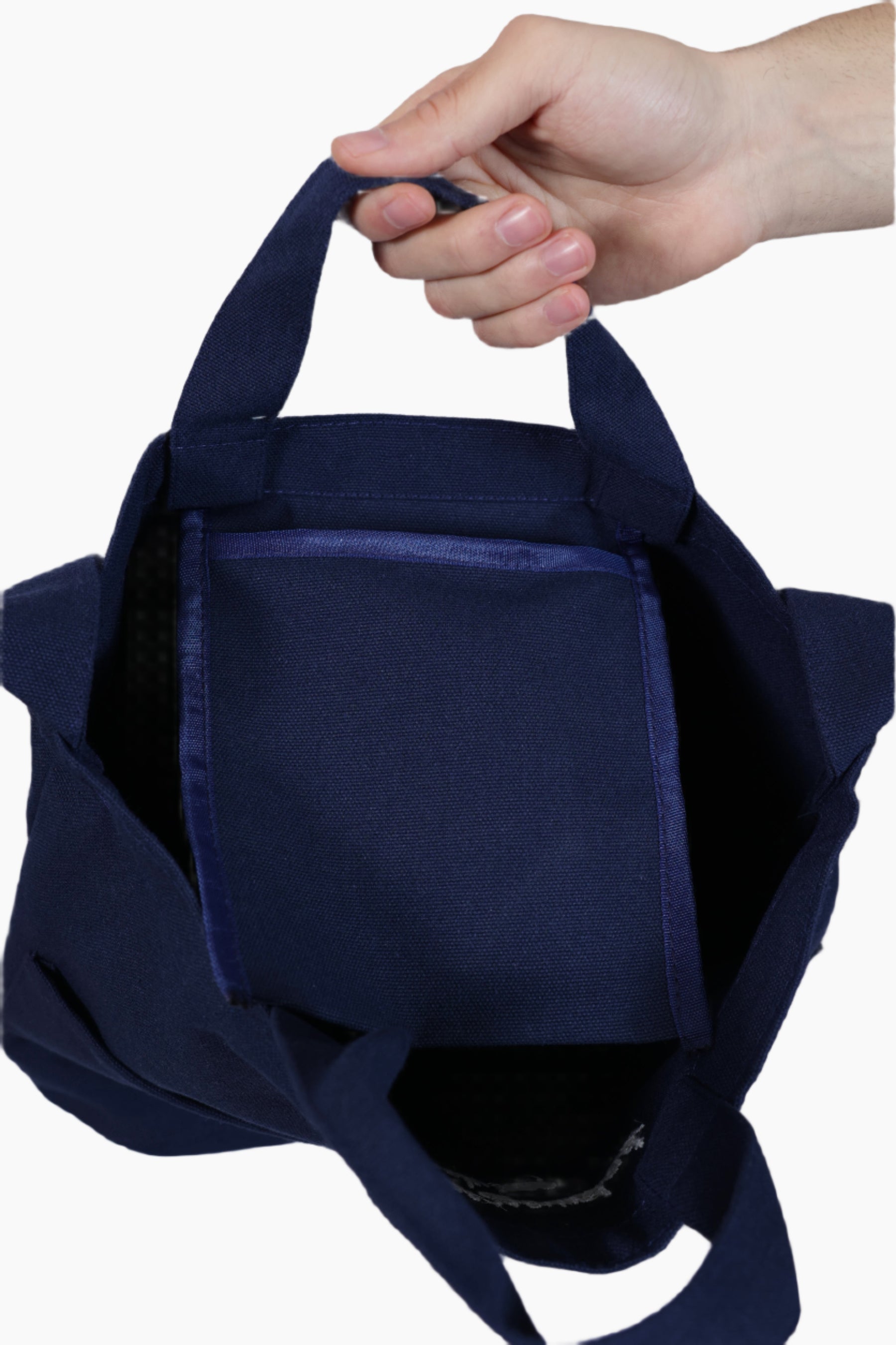 Navy blue tote bag held by a hand