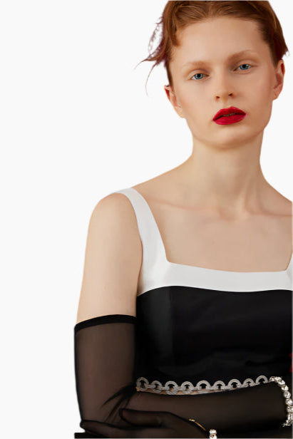 Woman wearing a black and white dress with sheer sleeves