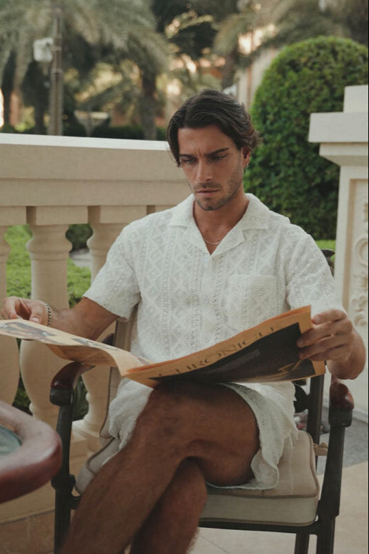 Man reading a book outdoors in a relaxed setting