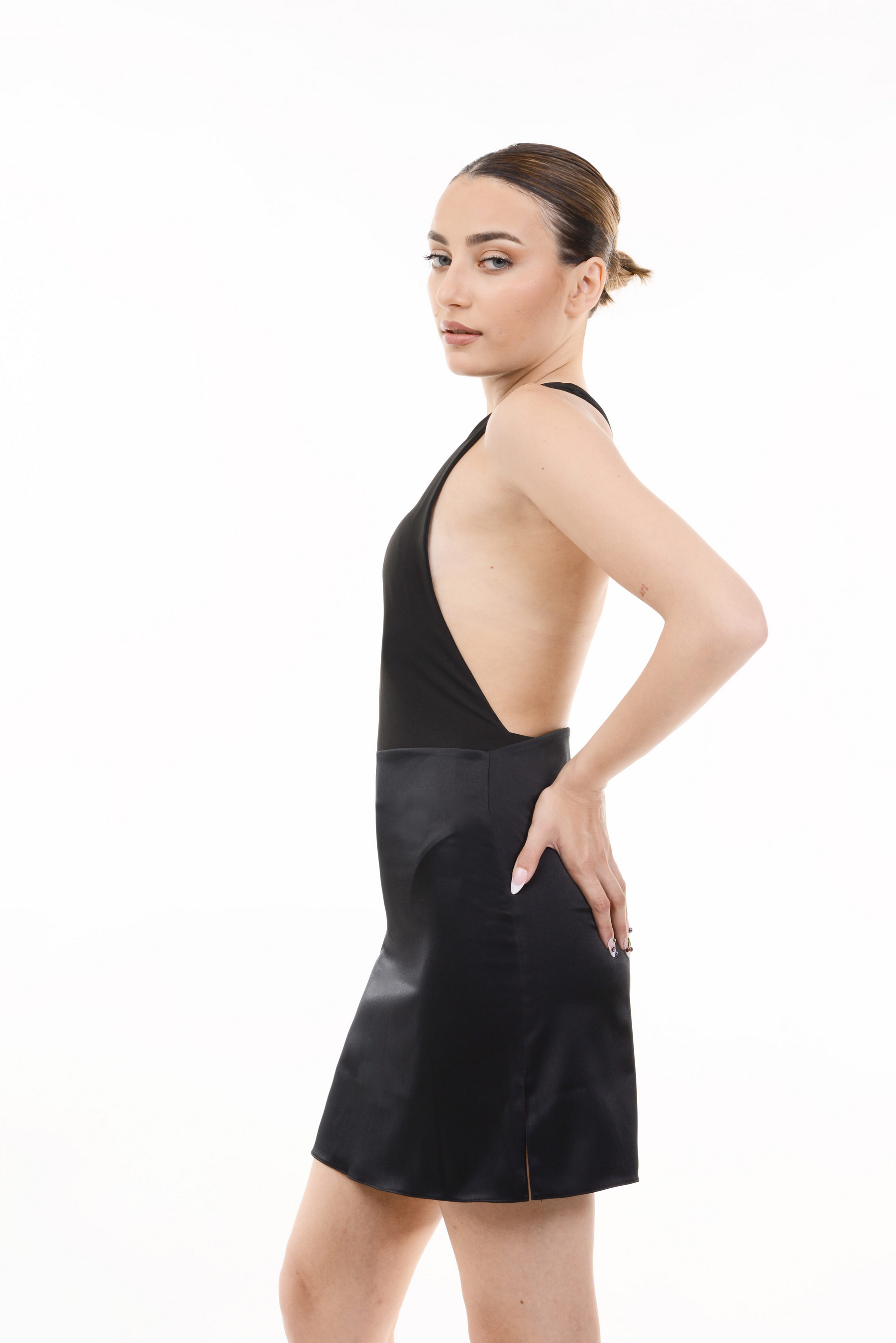 Woman wearing a black one-shoulder bodysuit on a white background