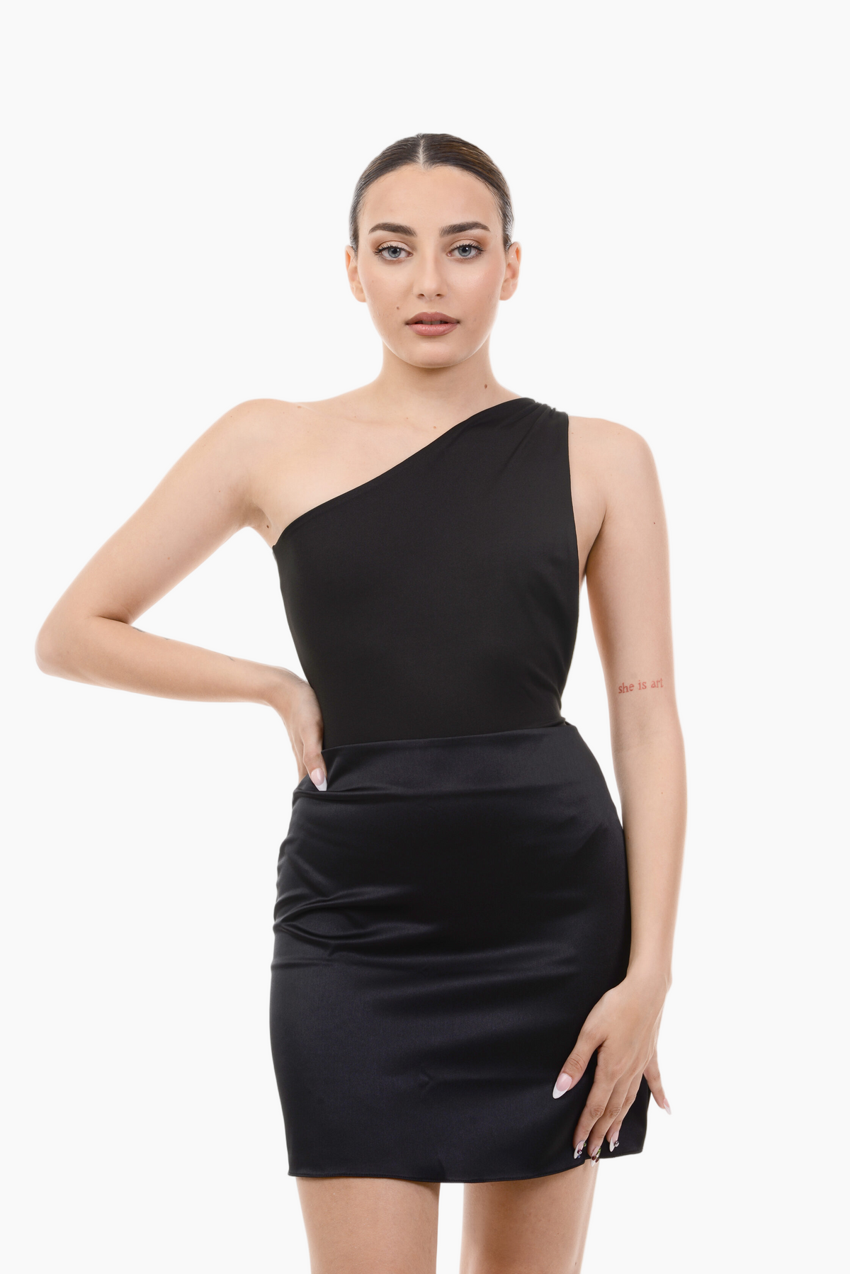 Woman wearing a black one-shoulder bodysuit on a white background