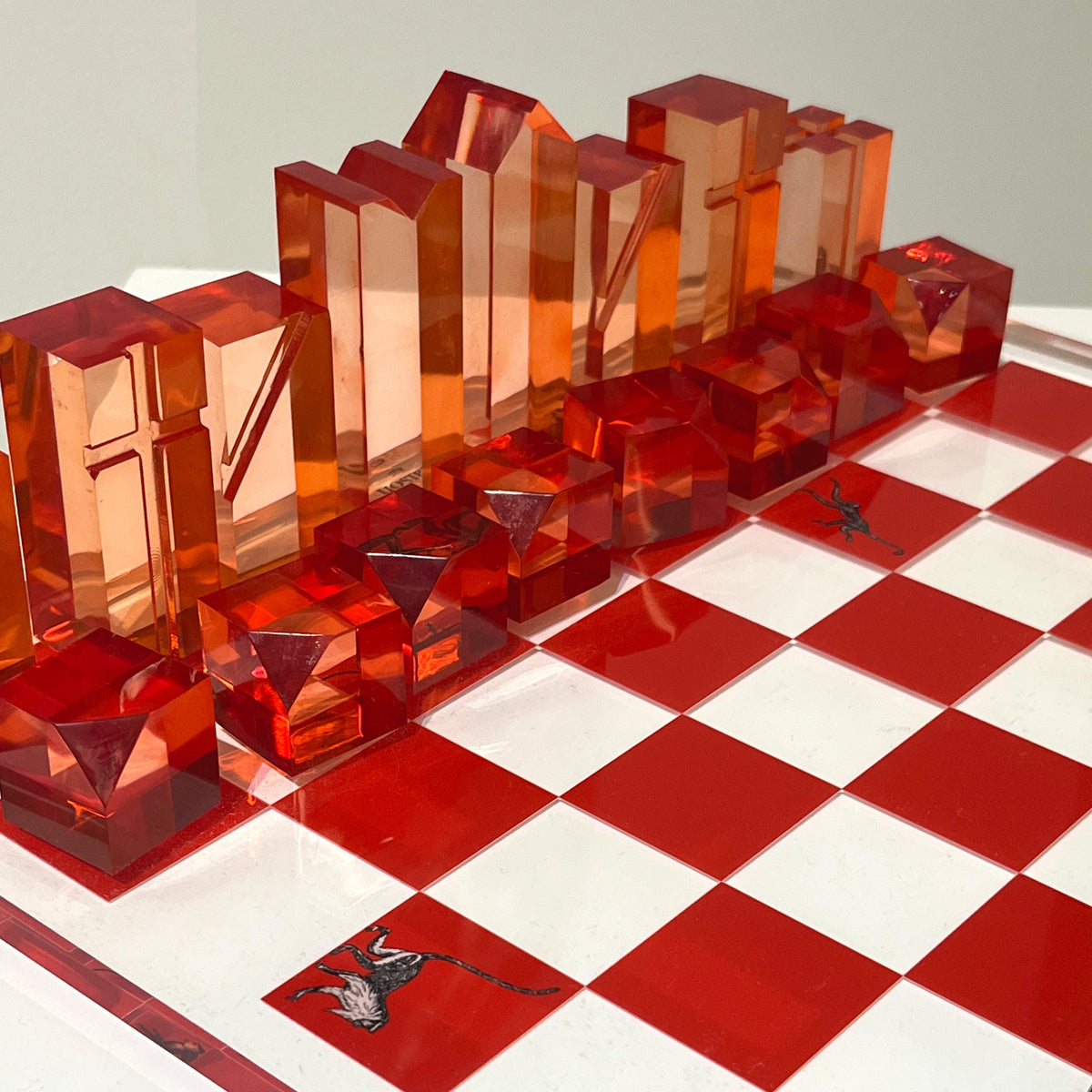 Transparent red chess pieces on a red and white checkered chessboard.