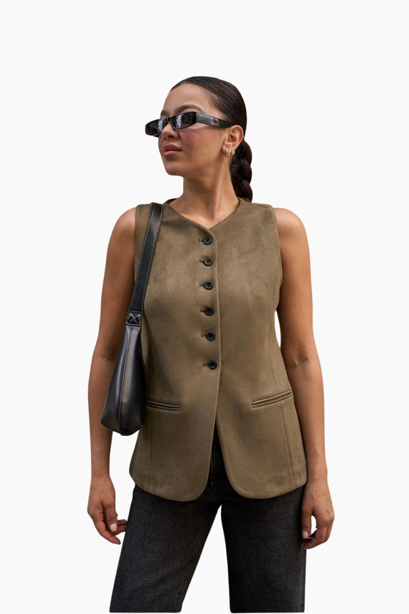 Woman wearing a brown vest with black buttons
