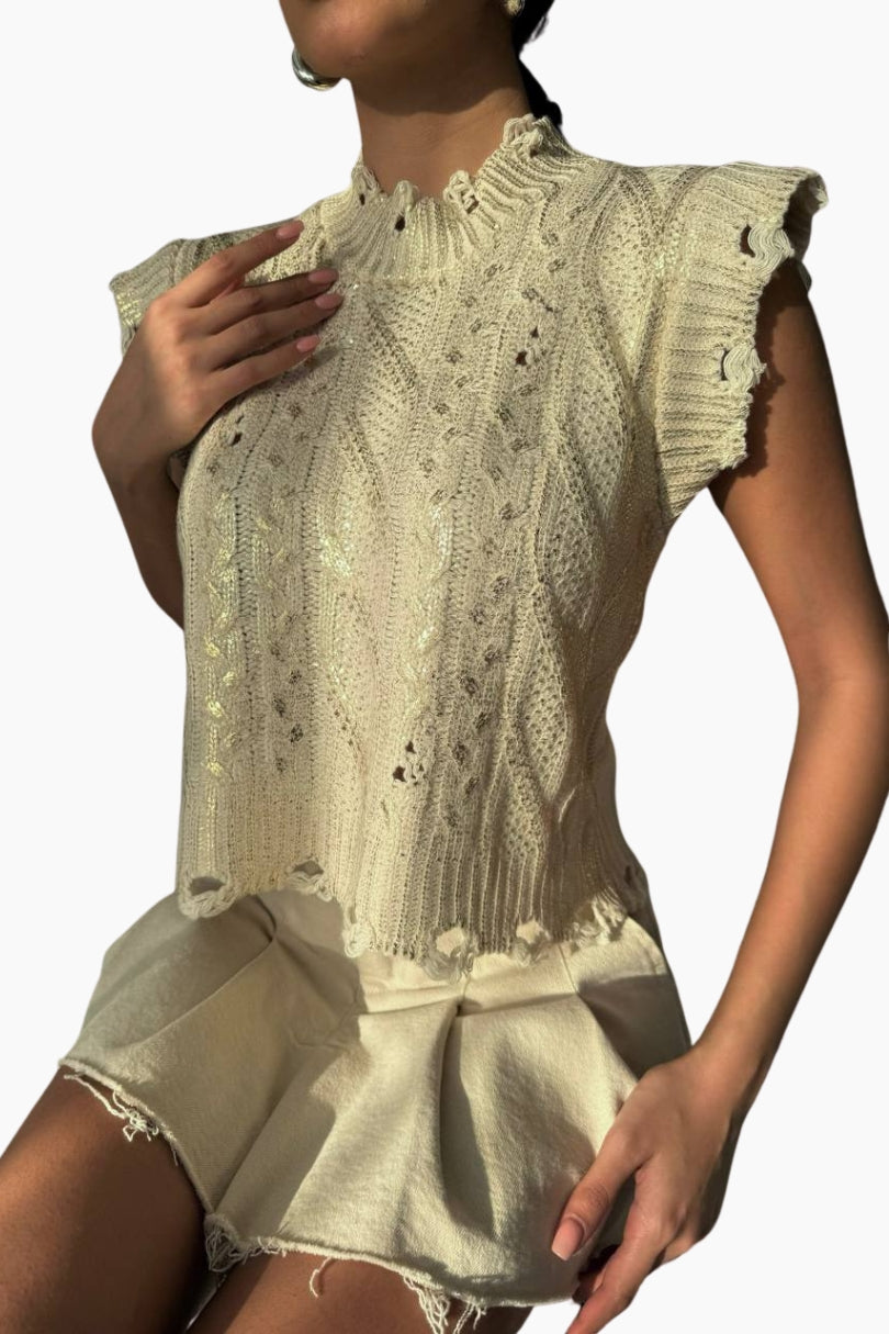 Woman wearing a light-colored lace top and shorts