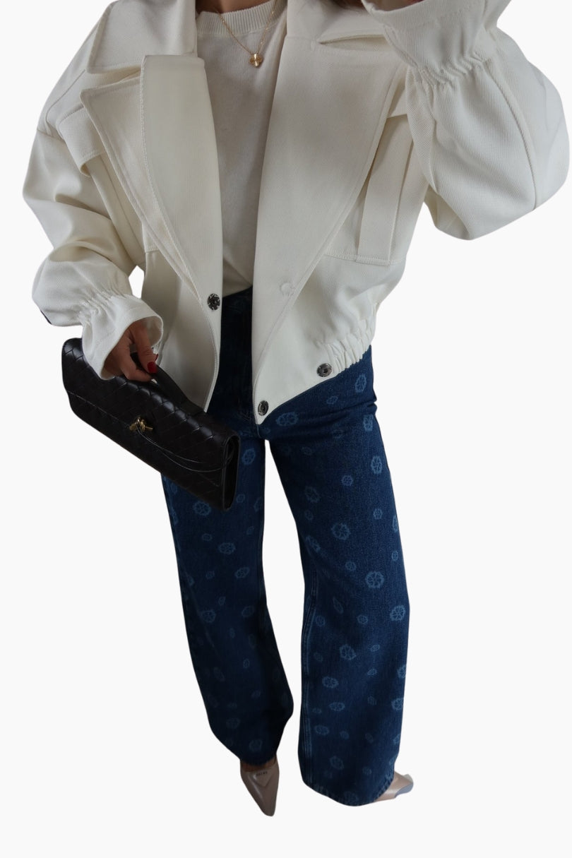 Person wearing a white jacket, white shirt, and blue patterned pants