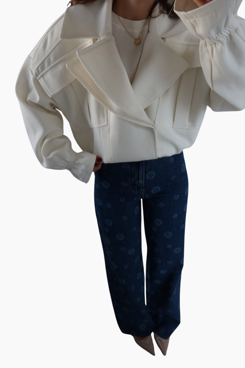 Person wearing a white jacket and blue jeans