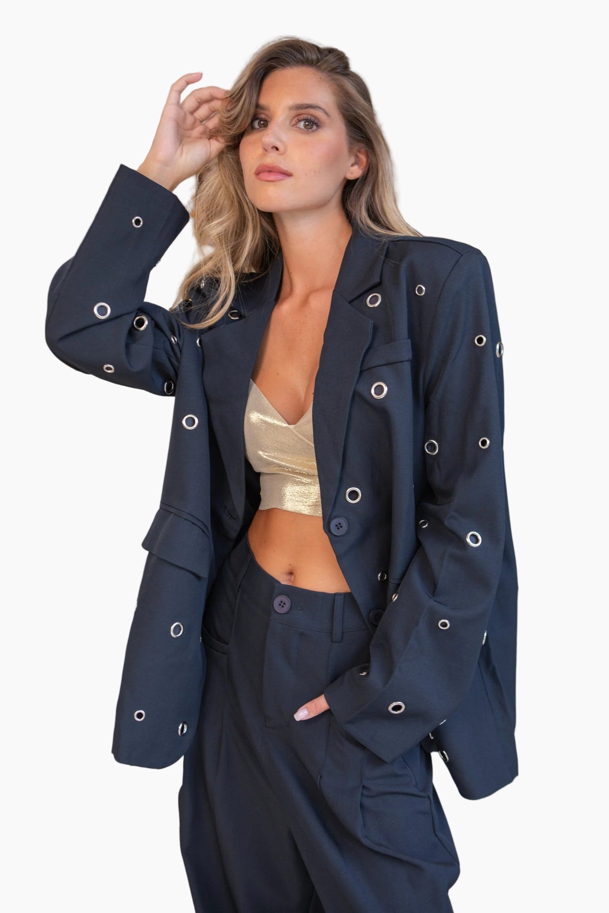 Woman wearing a navy-blue suit outfit with gold crop top