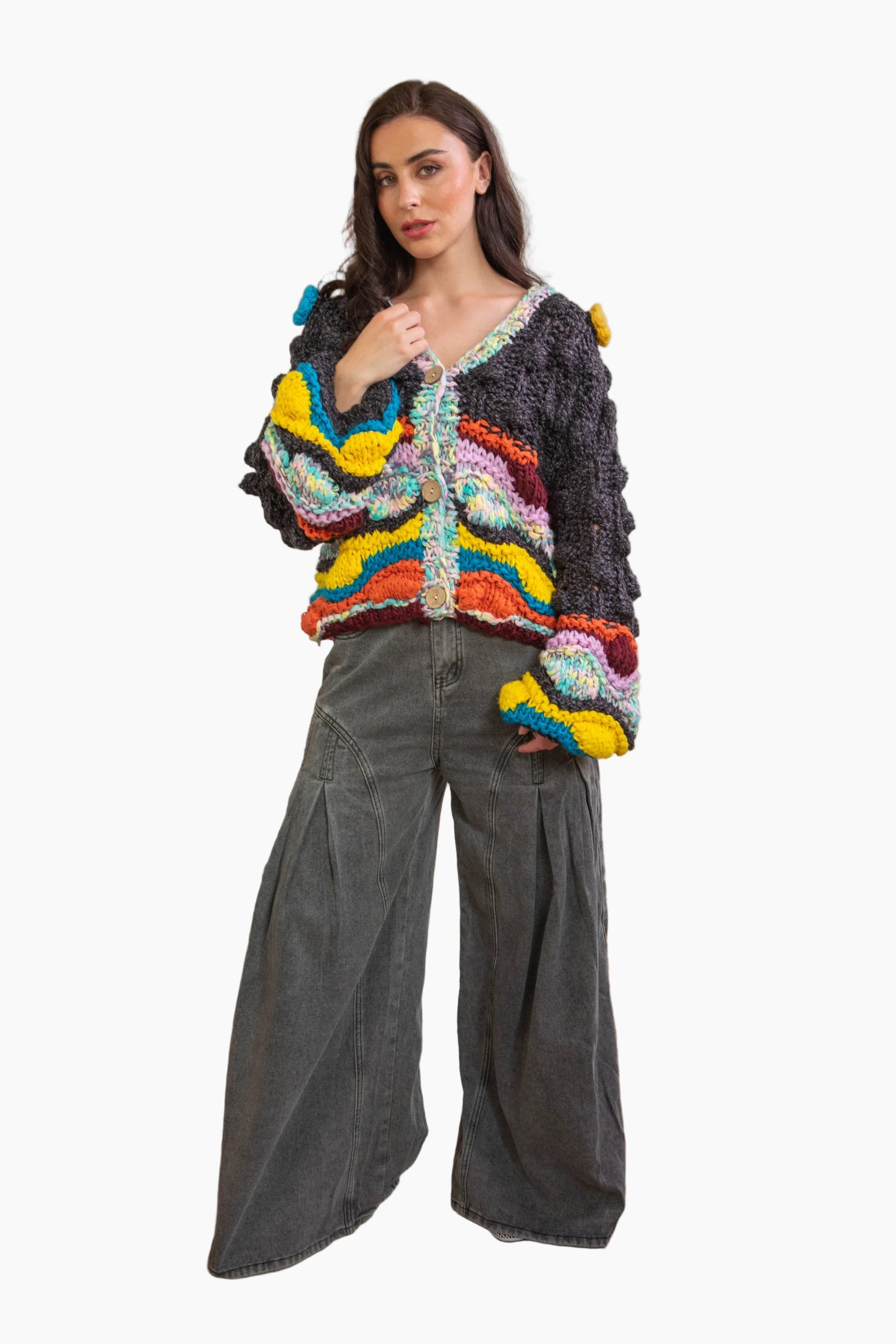Woman wearing a colorful knitted sweater and gray wide-leg pants