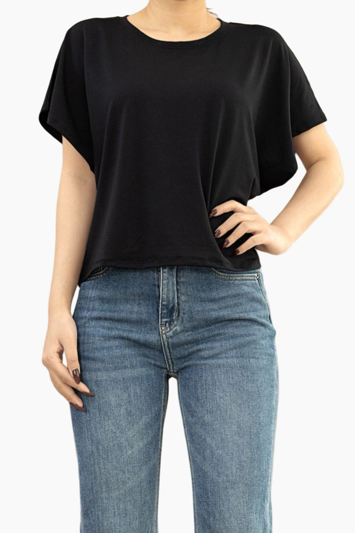 Person wearing a black t-shirt and blue jeans