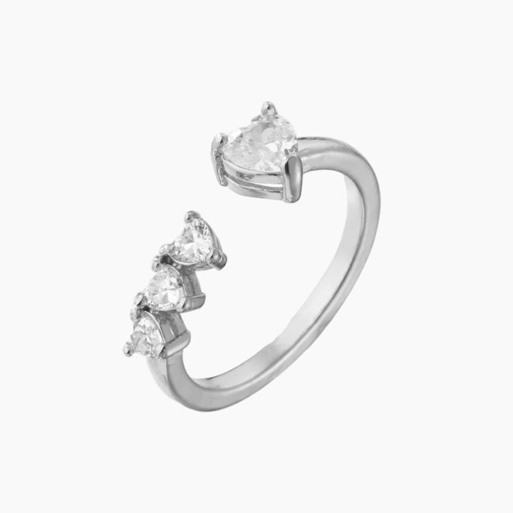 Silver ear cuff with heart-shaped gemstones on a white background