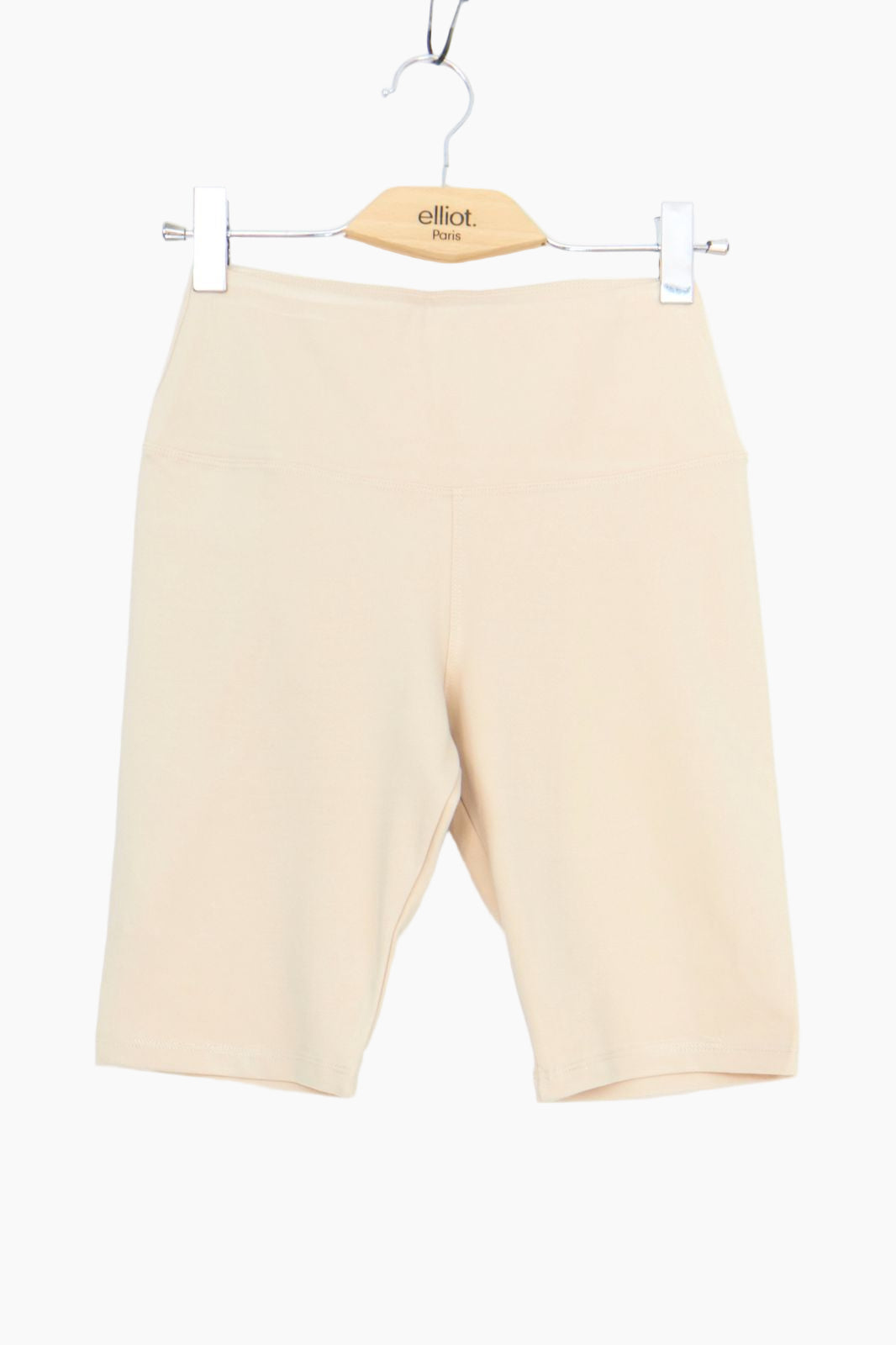 Beige shorts on a hanger with 'elliot' brand label