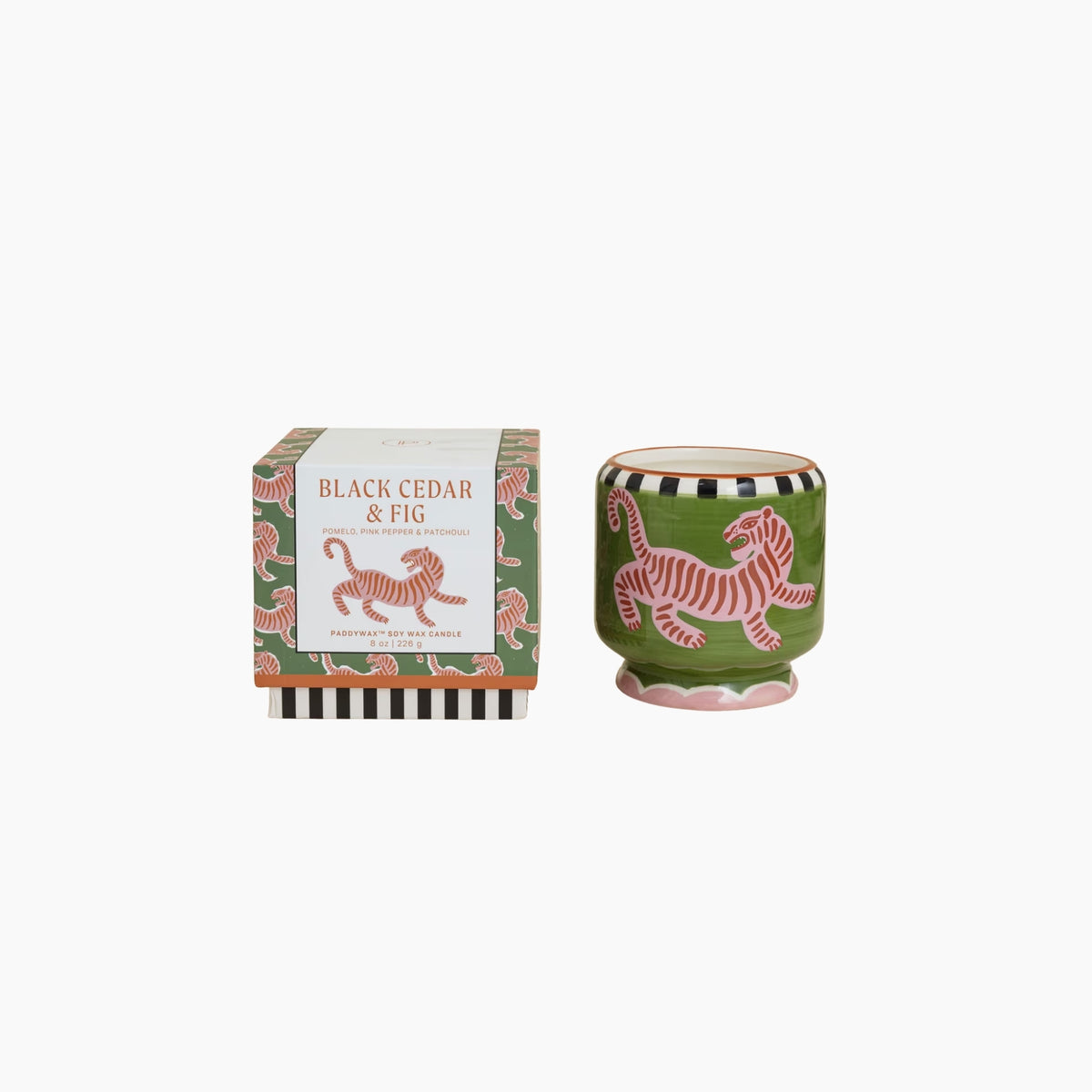 Green candle with tiger design and packaging labeled 'Black Cedar & Fig' on a white background