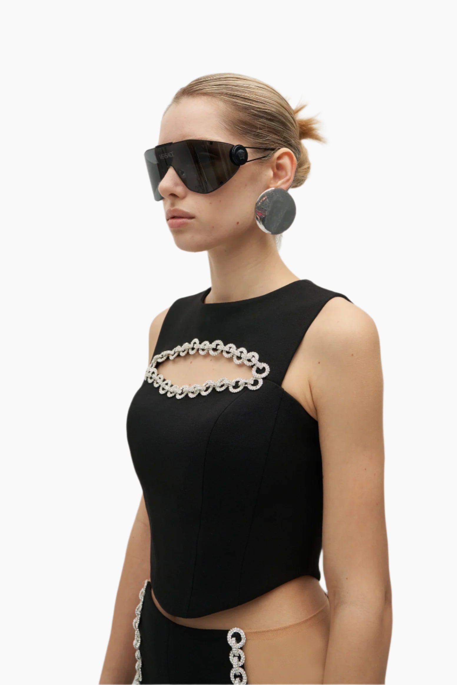 Woman wearing a black sleeveless top with chain details and sunglasses
