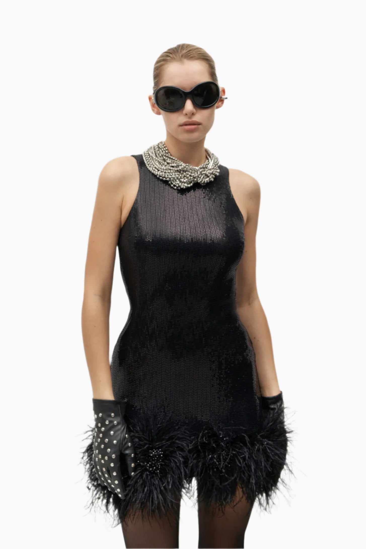 Model wearing a black dress with feather details, black gloves, and sunglasses