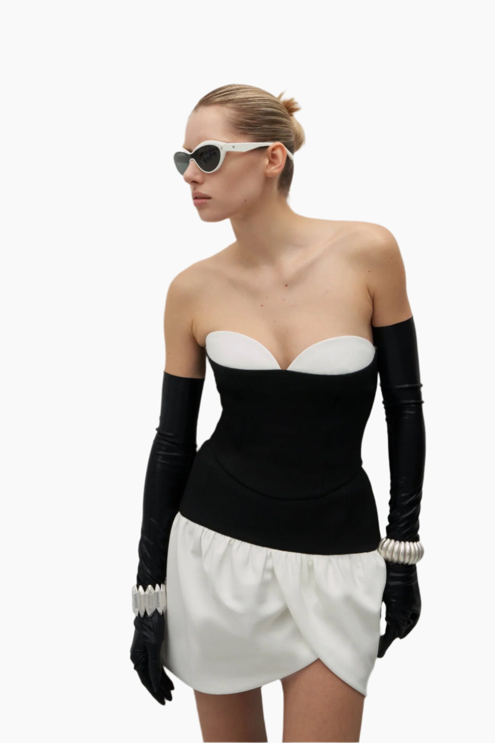 Woman wearing a black and white outfit with long gloves and sunglasses