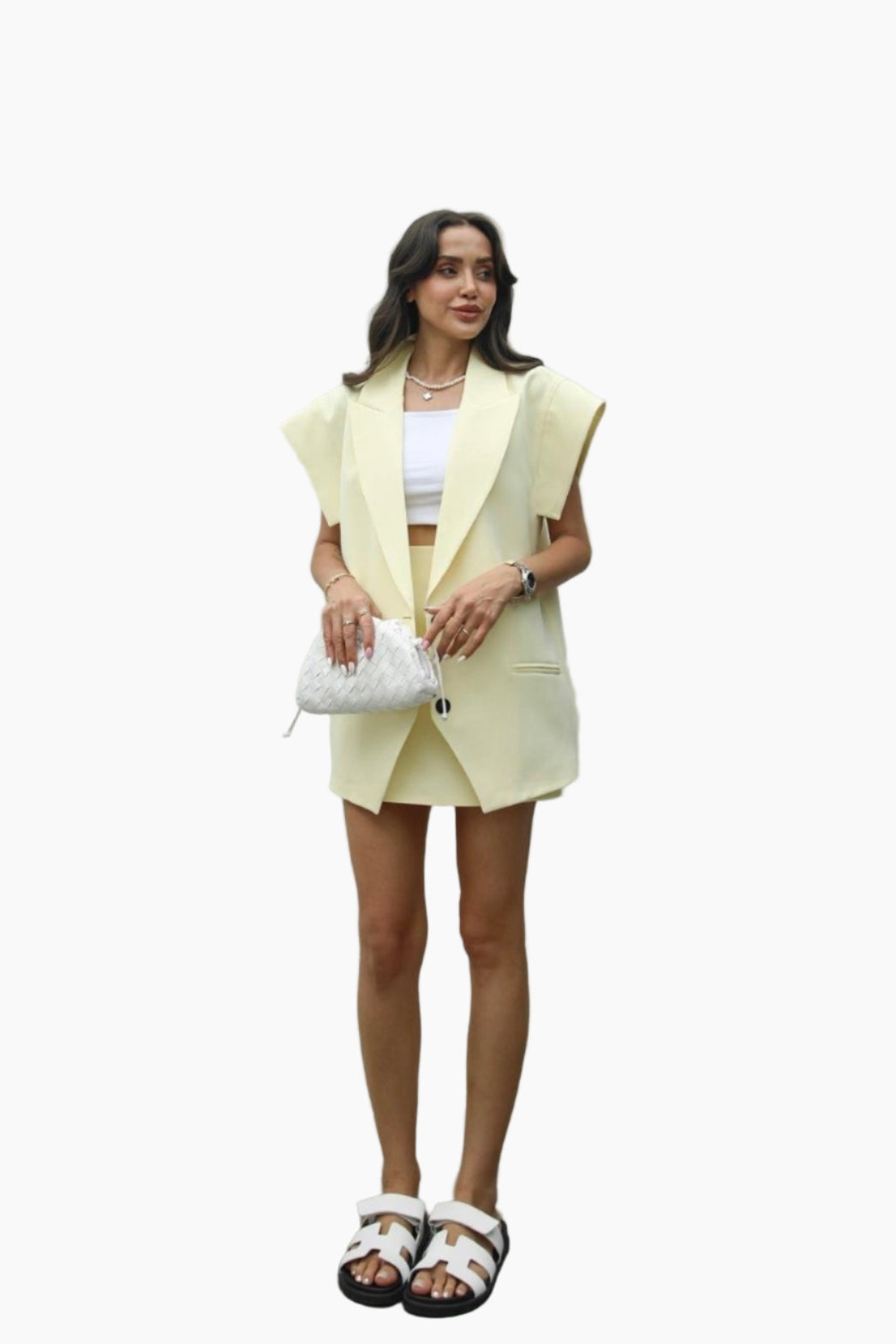 Woman wearing a light yellow blazer and skirt set on a white background