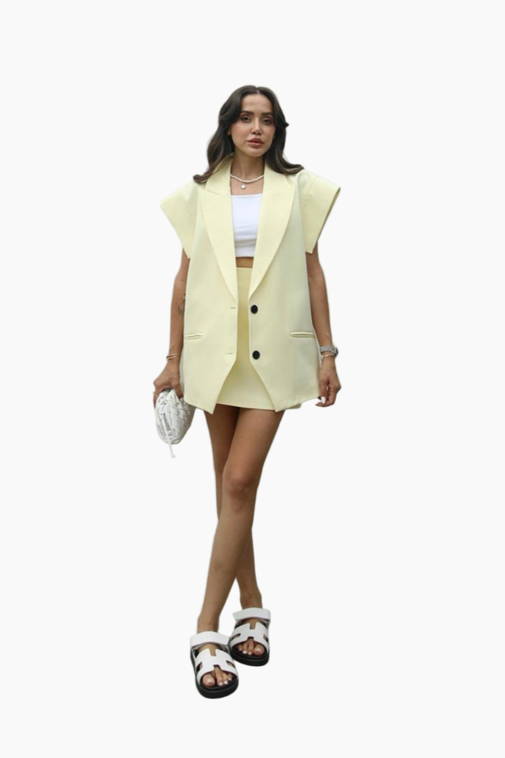 Woman wearing a light yellow blazer and skirt set on a white background