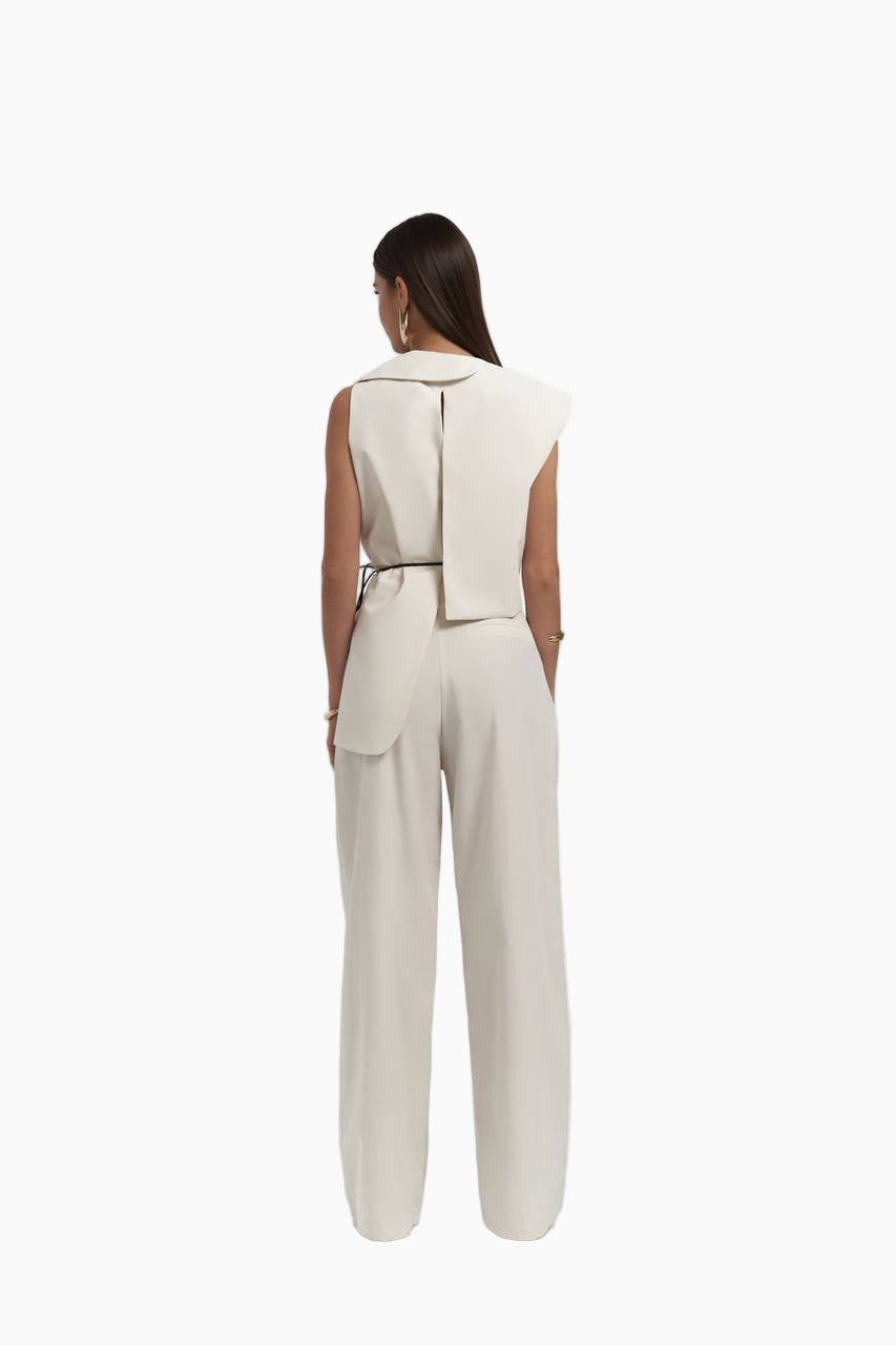 Woman wearing a beige jumpsuit with a wide belt on a white background